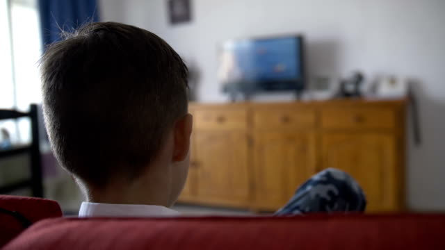 boy-sits-on-the-sofa-in-front-of-the-TV-and-switches-the-channels