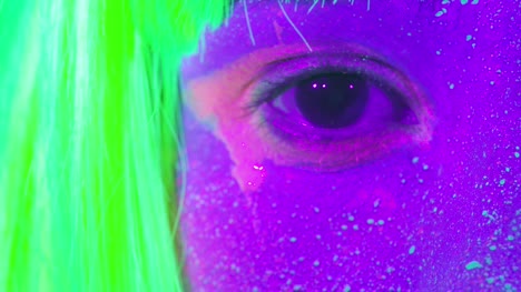 Closeup-woman-eyes-with-fluorescent-make-up-in-green,-wig,-creative-makeup-look-great-for-nightclubs.-Halloween-party,-shows-and-music-concept---slow-motion-video