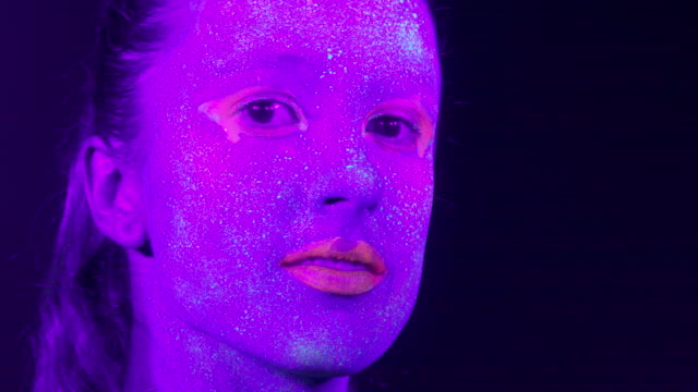 Closeup-rostro-de-la-mujer-con-maquillaje-fluorescente,-maquillaje-creativo-lucen-muy-bien-para-discotecas.-Concepto-de-fiesta,-espectáculos-y-música-de-Halloween---slow-motion-video