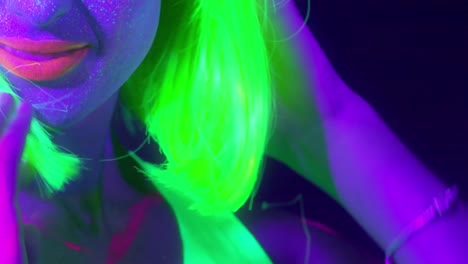 Slow-motin-of-beautiful-sexy-women-with-fluorescent-make-up-and-clothing-dancing-in-neon-light.-Night-club,-Party-Concept.