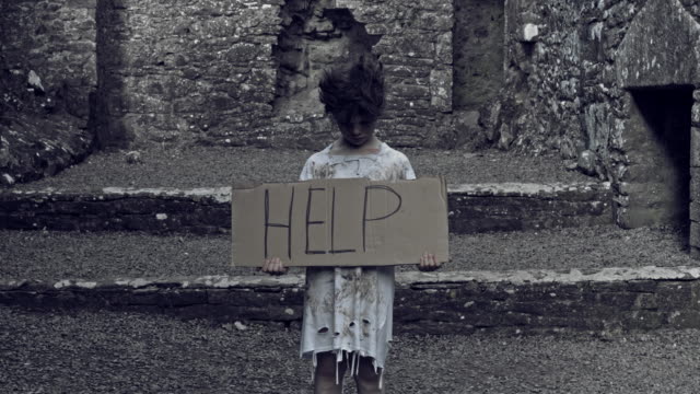 4k-Horror-Shot-of-an-Abandoned-Child-Holding-"Help"-on-cardboard