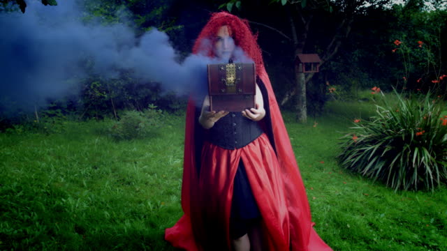 4k-Halloween-Shot-of-Red-Riding-Hood-Holding-a-Box-with-Coloured-Smoke