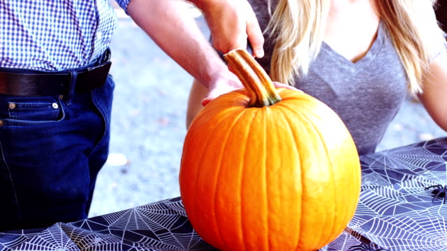Man-carving-a-pumpkin-to-make-halloween-lantern