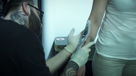 Mano-de-4-k-tatuaje-artista-preparación-del-cliente-con-el-dibujo