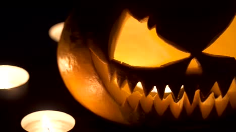 Two-pumpkins-are-on-the-table,-and-candles-are-burning-around.-Halloween-art-design.