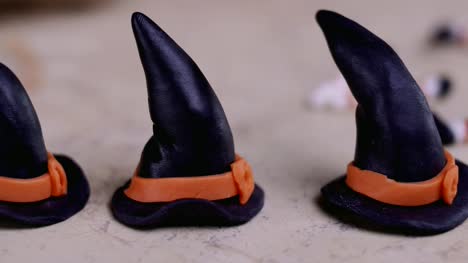 Baker-macht-Vereisung-Hut-und-Bein-für-Hexe-zum-Dekorieren-von-Muffins.-Halloween-Konzept