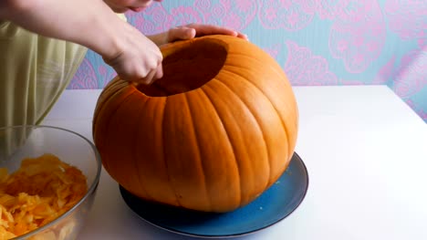Halloween.-Children's-hands-hollow-out-a-pumpkin-to-make-a-jack-o-lantern