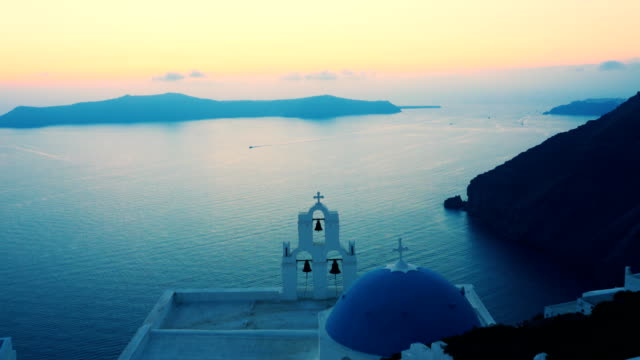 sunset-at-the-famous-three-bells-in-fira,-santorini