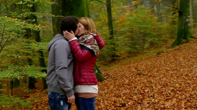 romantic-kiss-between-young-lovers-in-the-forest-in-autumn--romance,-kiss,nature