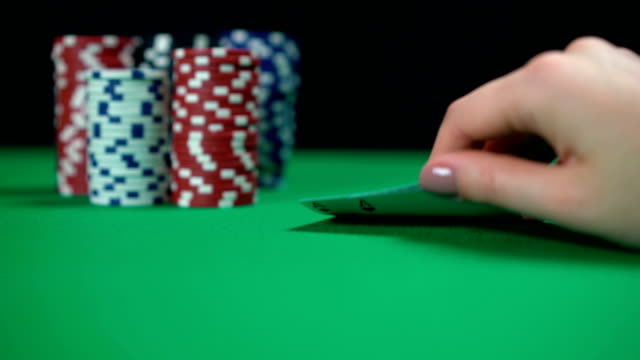 Pair-of-aces,-lucky-cards.-Poker-player-checking-hand-before-making-bets