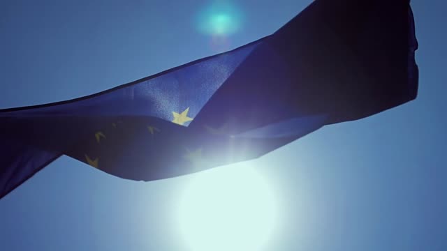 Winken-EU-Flagge-im-Wind-mit-einem-blauen-Himmel.