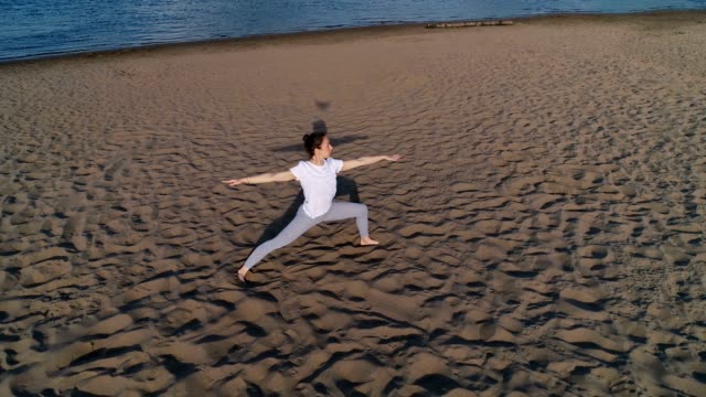 Mujer-haciendo-yoga-en-la-playa-de-arena-de-río-en-la-ciudad.-Hermosa-vista.