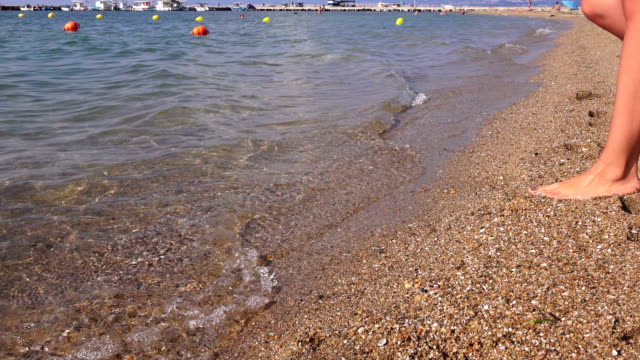 Beine-eines-Mädchens-auf-Meer-Strand-Hintergrund