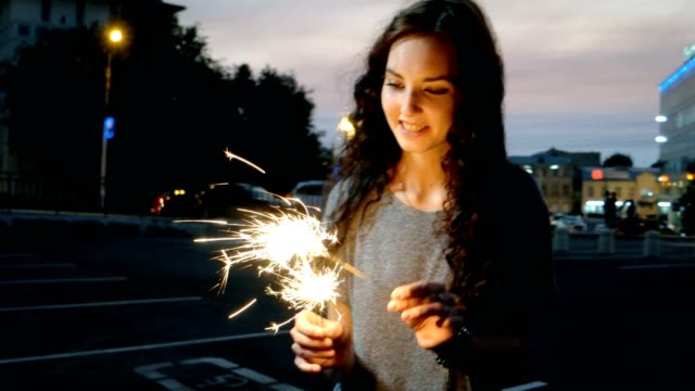 Teenage-Girl-Start-Sparklers-In-The-Night-Street-In-Front-Of-City-Lights
