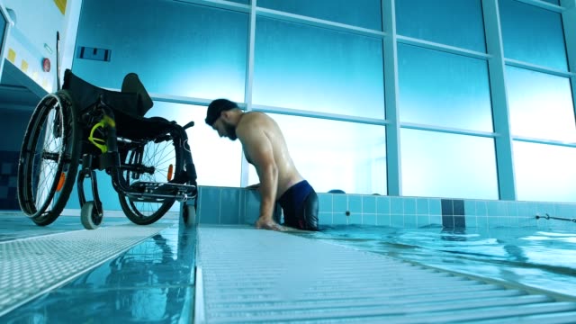Behinderte-Mensch-steigt-aus-dem-Swimming-Pool.-Seitenansicht