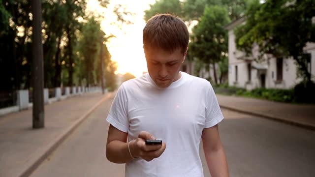 Hombre-con-smartphone-caminando.-Cámara-lenta
