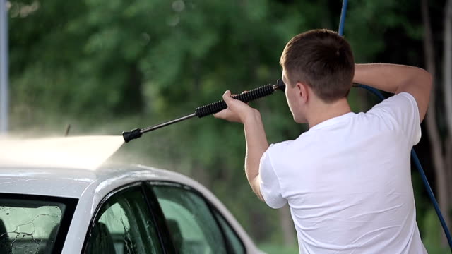 man-in-a-t-shirt-white-car-washes.-Slow-motion