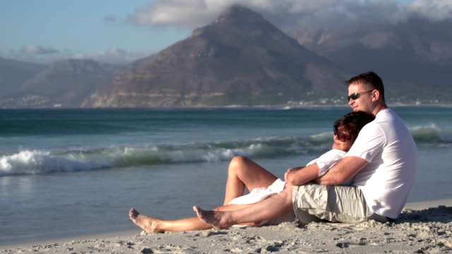 Pareja-sentada-en-la-romántica-abrazar-en-la-playa,-Ciudad-del-Cabo,-Sudáfrica