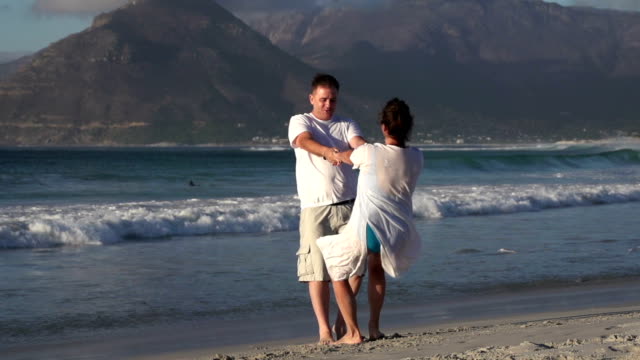 Slow-motion-of-romantic-couple-spinning-around-on-the-beach,-Cape-Town,South-Africa
