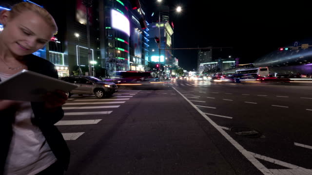 Timelapse-of-woman-with-tablet-PC-in-night-Seoul,-South-Korea