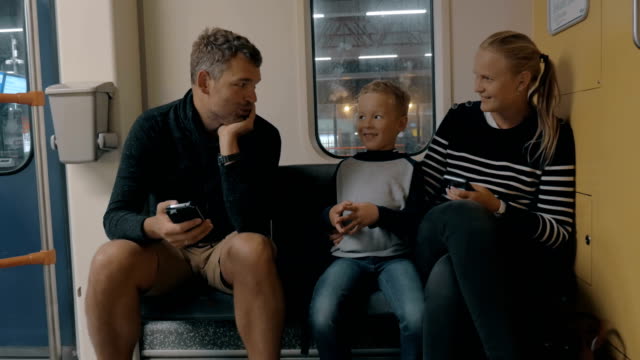 Blick-auf-glückliche-Familie-im-Bahnausflug-mit-Smartphone,-Amsterdam,-Niederlande