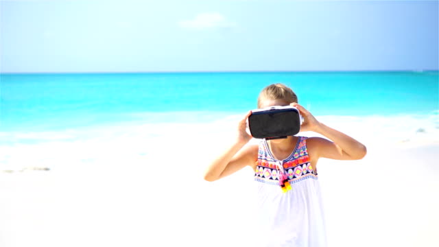 Entzückendes-kleine-Mädchen-mit-VR-virtual-Reality-Brille-am-weißen-Strand.