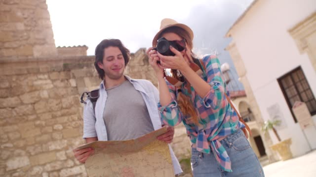 Tourists-with-map-and-camera-taking-photos-in-old-town