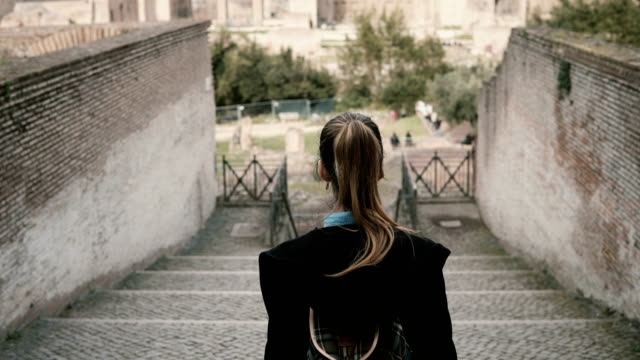 Joven-bonita-a-mujer-turístico-bajando-las-escaleras-en-el-centro-antiguo-de-Roma,-Italia-a-Roman-Forum