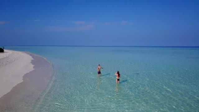 v04197-fliegenden-Drohne-Luftaufnahme-der-Malediven-weißen-Sandstrand-2-Personen-junges-Paar-Mann-Frau-Schwimmen-unter-Wasser-plantschen,-auf-sonnigen-tropischen-Inselparadies-mit-Aqua-blau-Himmel-Meer-Wasser-Ozean-4k