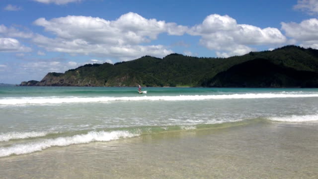 Paddleboarder-on-a-SUP-surfing-a-wave-at-Matauri-Bay,-Northland,-New-Zealand,-NZ