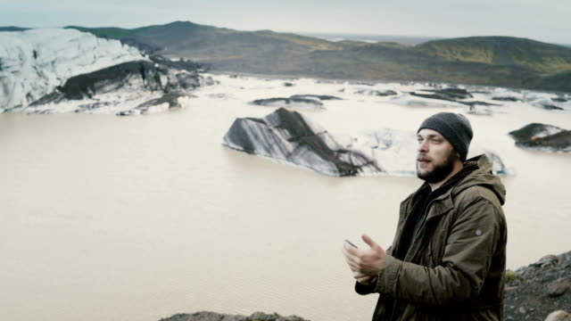 Joven-guapo-yendo-de-excursión,-tomar-fotos-de-la-laguna-de-hielo-Vatnajokull-con-glaciares-en-Islandia-en-smartphone