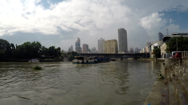 Tug-Boat-Towing-Barges-On-Pasig-River-toward-long-span-iron-bridge.-time-lapse