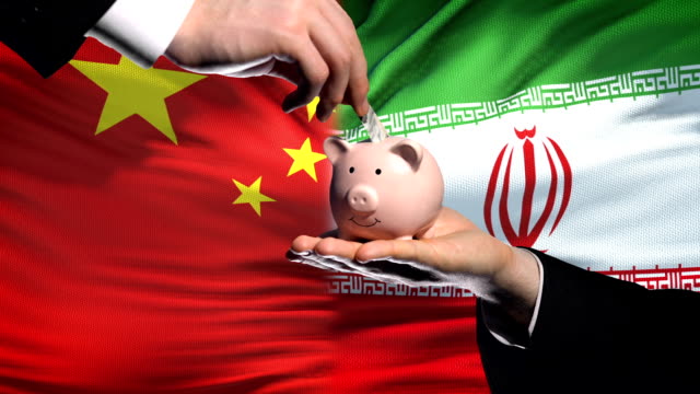 China-investment-in-Iran,-hand-putting-money-in-piggybank-on-flag-background