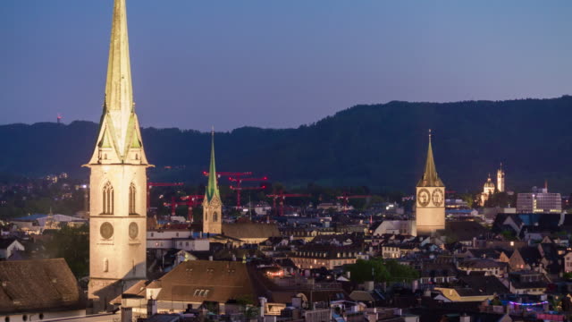 Suiza-Crepúsculo-iluminación-zurich-ciudad-famosas-iglesias-azotea-panorama-4k-timelapse