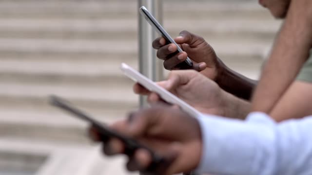 multiracial-hands-typing-on-smartphones--close-up
