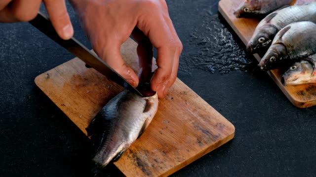 Man-cuts-gills-of-carp-fish.-Cooking-fish.-Hands-close-up.