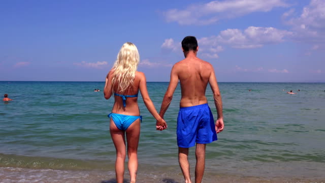 Young-couple,-man-and--beautiful-girl-walk-into-the-sea