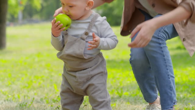 Mutter-und-Baby-Boy-mit-Apple-im-Park