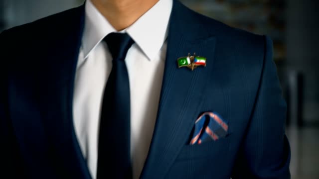 Businessman-Walking-Towards-Camera-With-Friend-Country-Flags-Pin-Pakistan---Equatorial-Guinea