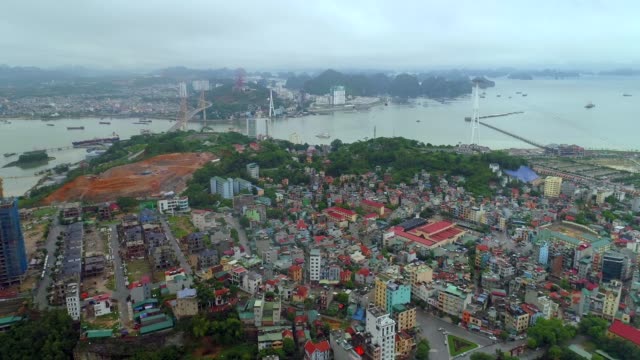 4k-Aerial-view-over-city-and-park-with-Bai-Tho-karst-mountain-Ha-long-bay.-Halong-City.
