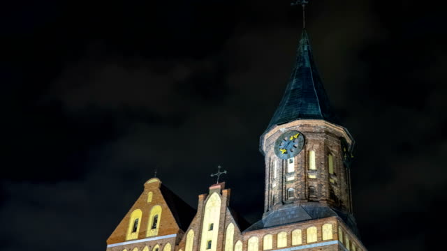 Illumination-on-a-historic-building.-Historic-Landmark.-Time-lapse.-Cathedral-of-Kant-in-Kaliningrad.-Old-medieval-at-night-against-the-sky.-An-ancient-tower-with-a-clock.-Timelapse.