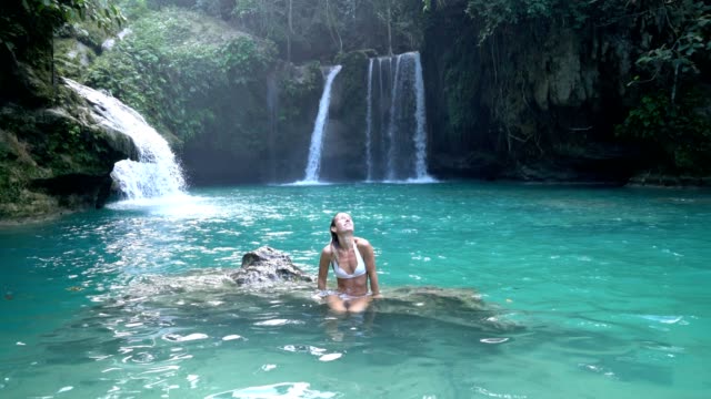 Junge-Frau-einen-schönen-Wasserfall-auf-der-Insel-Cebu-in-den-Philippinen-zu-betrachten.-Die-Leute-reisen-Natur-liebenden-Konzept.-Eine-Person,-die-nur-genießen,-Natur-und-Ruhe-in-einer-ruhigen-Umgebung