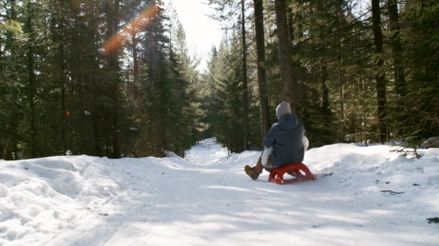 Siblings-Sledding-in-Beautiful-Winter-Forest