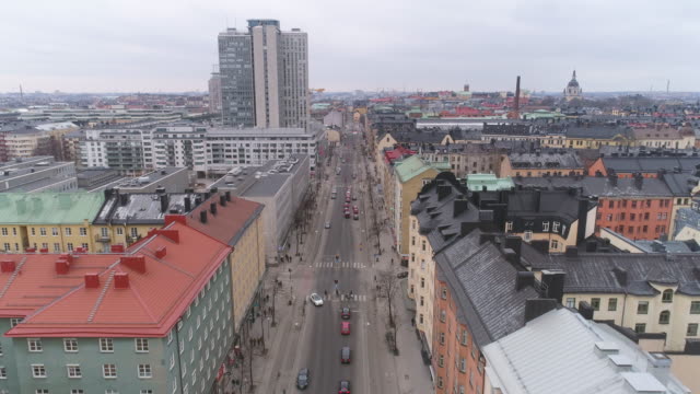 Stockholm-city-street-aerial-view.-Drone-shot-flying-over-street-and-buildings-in-Södermalm-district.-Cityscape-skyline-in-The-Capital-of-Sweden.-Skrapan-skyscraper-building-in-the-background