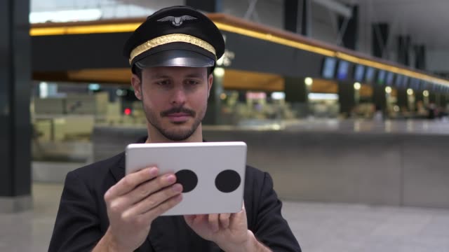 Young-Caucasian-pilot-checking-data-on-tablet-before-takeoff