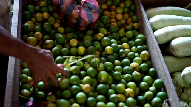 Vegetable-vendor-sale-fresh-limes-at-traditional-market