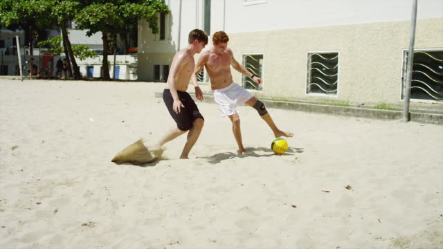 Friends-play-soccer-on-the-beach-in-Brazil.