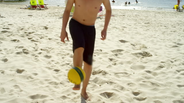 Amigos-la-práctica-las-habilidades-de-fútbol-en-la-playa-en-Brasil