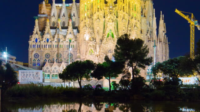 Sagrada-familia-en-la-noche-de-la-vista-del-estanque-de-reflexión-luz-4-K-lapso-de-tiempo-de-barcelona,-España