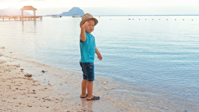 Cute-boy-throwing-pebbles-into-the-sea-slow-motion